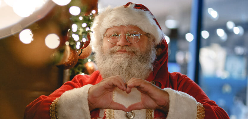 santa claus making a love heart shape with his hands